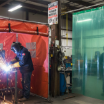 Welding tent and welding curtain side by side in an industrial worksite in Edmonton Alberta